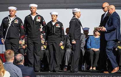 SAN DIEGO (Jan. 26, 2019) James and Joseph Monsoor, brothers to Michael Monsoor, pass the long glass to the first watch during the commissioning ceremony for the guided-missile destroyer USS Michael Monsoor (DDG 1001). DDG-1001 is the second Zumwalt-class destroyer ship to enter the fleet. It is the first Navy combat ship named for fallen Master-at-Arms 2nd Class (SEAL) Michael Monsoor, who was posthumously awarded the Medal of Honor for his heroic actions while serving in Ramadi, Iraq, in 2006. U.S. Navy photo by MC2 Alex Millar.