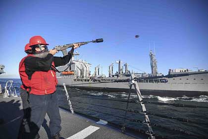 PACIFIC OCEAN (June 9, 2020) Gunner's Mate 2nd Class Katie Jolly, from Gates County, N.C., assigned to the Arleigh Burke-class guided-missile destroyer USS Ralph Johnson (DDG 114), fires a shot-line during a replenishment-at-sea with the Military Sealift Command fleet replenishment oiler USNS Henry J. Kaiser (T-AO 187). Ralph Johnson is part of the Nimitz Carrier Strike Group and is deployed conducting maritime security operations and theater security cooperation efforts. U.S. Navy Photo by MC3 Anthony Collier.