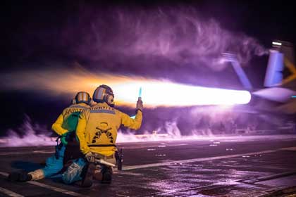 Super Hornet Launch: Sailors monitor the launch of an F/A-18E Super Hornet on the flight deck of the aircraft carrier USS Nimitz in the U.S. 7th Fleet area of operations.